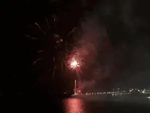 Fireworks Are Displayed Over A Body Of Water In The Night Sky