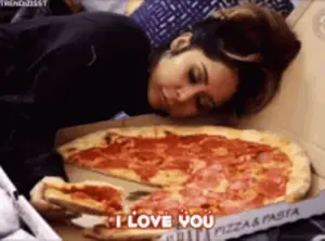 A Woman Is Laying On A Bed Next To A Pizza Box That Says " I Love You "