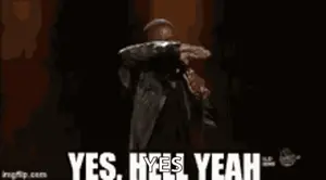 A Man Is Standing On A Stage Holding A Microphone And Saying Yes , Yes , Yeah .