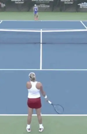 A Woman Is Holding A Tennis Racquet On A Blue Tennis Court