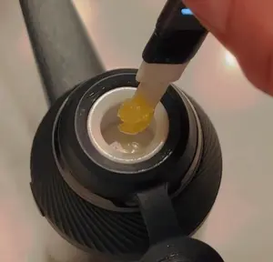 A Person Is Plugging A Charger Into A Device With A Yellow Substance In It