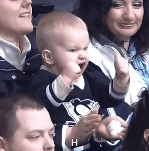 A Baby Wearing A Penguins Jersey Holds Up His Fist In The Air
