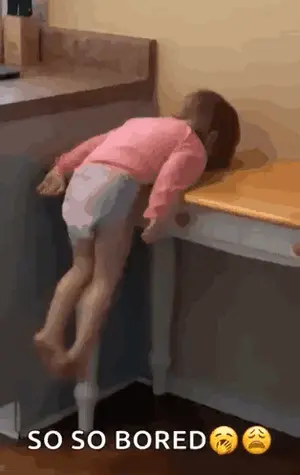 A Little Girl Is Laying On A Table With Her Head On The Table .