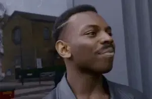 A Man With A Mustache Is Smiling And Looking At The Camera .