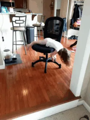 A Little Girl Is Laying On A Chair In A Room