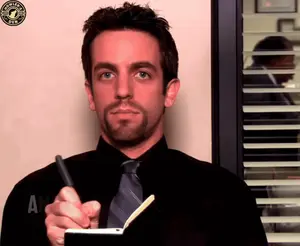 A Man In A Black Shirt And Tie Is Writing In A Notebook With A Starbucks Logo In The Corner