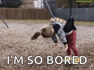 A Little Girl Is Hanging Upside Down On A Swing And The Words `` I 'M So Bored '' Are Written Below Her .