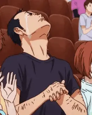 A Man In A Black Shirt Is Crying While Sitting In A Theatre .