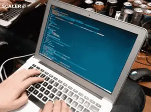 A Person Is Typing On A Laptop With Scaler 4 On The Bottom Right