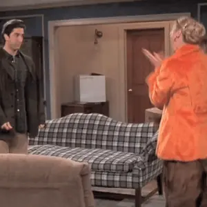 A Man And A Woman Are Standing In A Living Room With Plaid Furniture