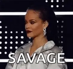 A Woman Is Standing In Front Of A Black Background And The Word Savage Is On The Screen .