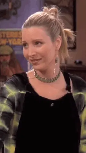 A Woman Wearing A Necklace And Hoop Earrings Stands In Front Of A Poster That Says ' Stones New York '