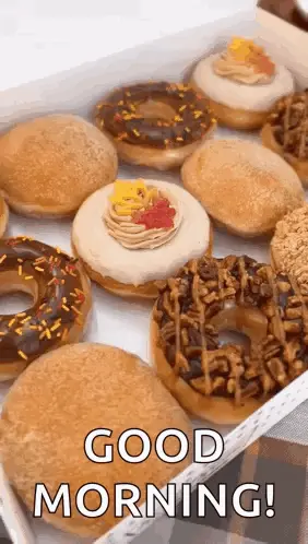 A Box Of Donuts With Different Flavors And Toppings Is Sitting On A Table .