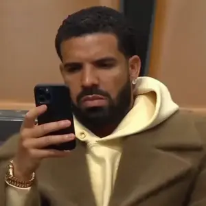 A Man With A Beard Is Taking A Selfie With His Cell Phone .