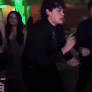 A Man In A Blue Shirt And Tie Is Dancing In A Club