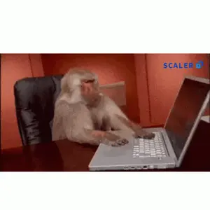 A Monkey Sits At A Desk Typing On A Laptop With A Scaler Logo Behind It