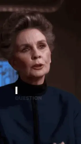 A Bald Man Wearing A Red Sweater Is Covering His Face With His Hand .