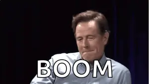 A Man In A Blue Shirt Is Making A Funny Face And The Word Boom Is On The Screen Behind Him
