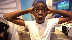 A Man In A White Shirt Has His Hands On His Head And His Mouth Open