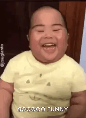 A Baby Is Laughing And Smiling While Wearing A Yellow T-Shirt .