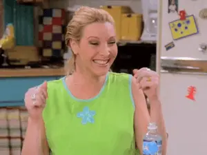 A Woman In A Green Tank Top Is Smiling While Holding A Bottle Of Water .