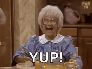 An Elderly Woman Is Sitting At A Table With A Glass Of Orange Juice And A Pitcher Of Orange Juice .