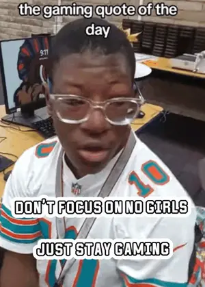 A Man Wearing A Miami Dolphins Jersey Is Sitting At A Desk